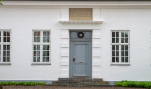 Indgangsdør til stor, hvid bygning